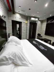 伊维Hotel Plata by Bossh Hotels的卧室配有带白色床单和屏风的床