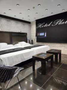 伊维Hotel Plata by Bossh Hotels的酒店客房设有一张大床和两张桌子。