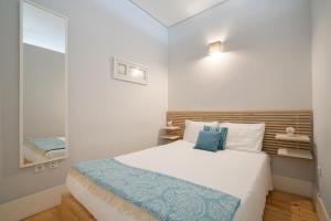 波尔图OPO Downtown Blue的一间小卧室,配有一张床和镜子