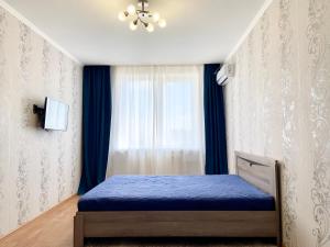 斯塔夫罗波尔Апартаменты В ЦЕНТРЕ ЖК "Шоколад"的一间卧室设有蓝色的床和窗户。