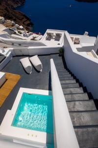 易莫洛林Santorini Delux的一座带楼梯的房屋的顶部游泳池