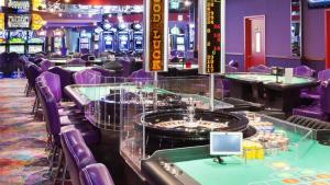 棕榈滩拉卡班纳旅游BRC一室公寓套房酒店的赌场,设有紫色椅子和桌子以及赌博机