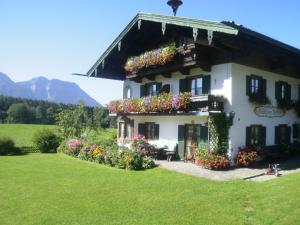 因泽尔Gästehaus Restner - Chiemgau Karte的院子里有鲜花的大白色房子