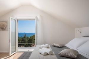 米欧纳WATERFRONT SEA DREAM VILLA的白色的卧室设有床和大窗户
