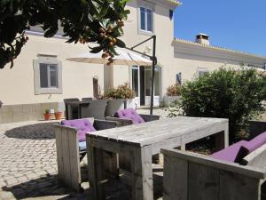 圣布拉什迪阿尔波特尔Casal da Eira的一张带紫色椅子和遮阳伞的木桌