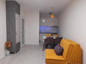 波德戈里察Apartment Diamond的客厅配有黄色的沙发和桌子