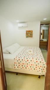 巴伊亚福尔莫萨Pousada ResDelMar的卧室配有带花卉图案的白色床