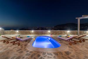 帕拉斯波罗斯Peters Place - Paros Resort的游泳池(晚上)设有2间休息室和1个游泳池