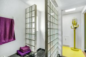 JellingGormsgade lejlighed的一间带镜子和紫色毛巾的浴室