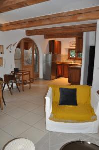 蒂尔凯姆Au Grès des Vignes的一间带白色沙发的客厅和一间厨房