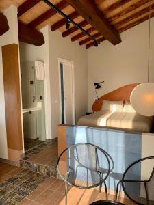 MusignanoIl Poggio di Musignano的配有一张床和一张桌子及椅子的房间