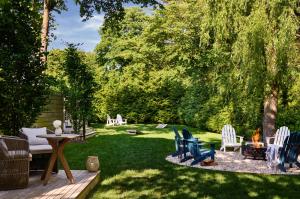 东汉普顿Journey East Hampton的后院配有椅子、桌子和壁炉