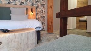 希勒Hotel Le Filou的一间卧室设有两张床和一张木柴桌。