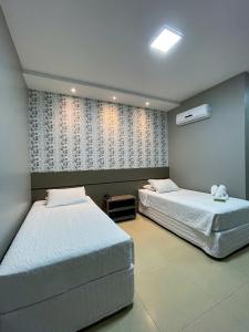 Lucas do Rio VerdeHotel Mandino的一间卧室设有两张床和窗户。