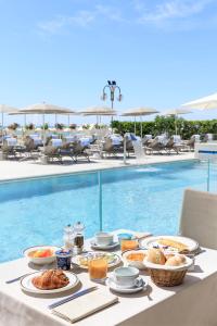 利多迪耶索罗卡瓦列利皇宫酒店的游泳池旁的餐桌上放着食物