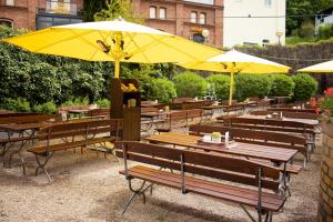 阿恩施塔特阿恩施塔特斯塔德特布瑞恩霍特公园酒店的一组桌子和椅子,配有黄色遮阳伞