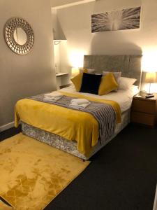 阿尼克乔治亚旅馆的卧室配有一张带黄色床单和枕头的大床。