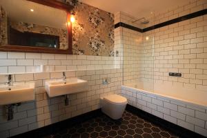 水晶宫Westow House的浴室配有2个盥洗盆、卫生间和浴缸。