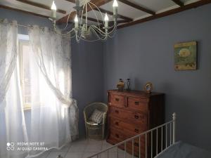 San Lorenzo NuovoAlloggio turistico Amalasunta的一间带吊灯、梳妆台和窗户的卧室