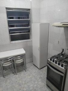 里约热内卢贡萨尔维斯海军上将公寓的厨房配有炉灶和白色冰箱。