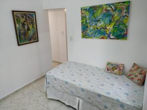 里约热内卢贡萨尔维斯海军上将公寓的卧室配有一张床,墙上挂有绘画作品