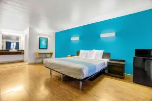 安德森安德森6号汽车旅馆的一间卧室配有一张蓝色墙壁的床
