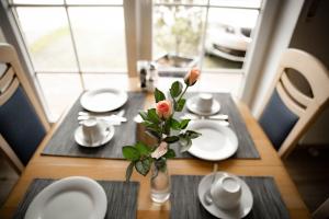 诺德代希Pension Frisia的一张带白板的桌子,一个花瓶上放着花
