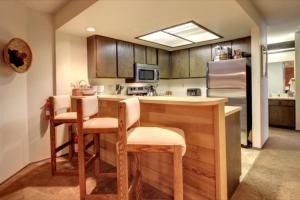 布赖恩峰Giant Steps 34 Ski In-out的厨房配有桌椅和冰箱。