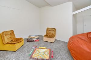 基督城Lavandula 4 - Christchurch Holiday Homes的客厅配有两把椅子和棋盘(位于地板上)