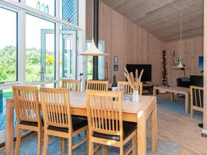 法贾德嘉德8 person holiday home in Ulfborg的一间带木桌和椅子的用餐室