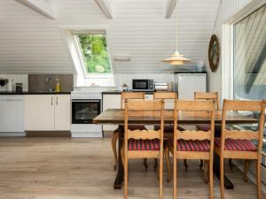 埃贝尔托夫特6 person holiday home in Ebeltoft的厨房配有餐桌和椅子