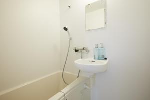 东京Designers Hotel Siesta的白色的浴室设有水槽和镜子