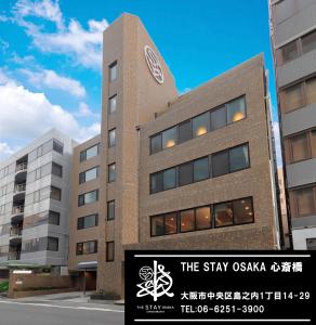 大阪The Stay Osaka Shinsaibashi的一座建筑的顶部有钟