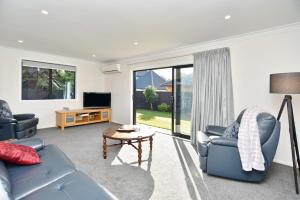 基督城Lavandula 3 - Christchurch Holiday Homes的带沙发、桌子和电视的客厅