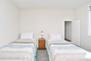 基督城Lavandula 3 - Christchurch Holiday Homes的白色墙壁客房的两张床
