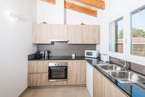 卡兰博希Villa Calan Bosch Es Bruc的一个带木制橱柜和水槽的厨房