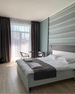 敖德萨SeaLine Apart-Hotel的一间卧室设有一张床和一个大窗户