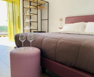 博斯科特雷卡塞Vesuvio Inn Bed & Wine Experience的一间卧室配有床和两杯酒杯