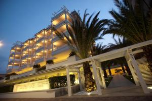 切尔维亚滨海别墅Spa度假酒店的前面有棕榈树的酒店