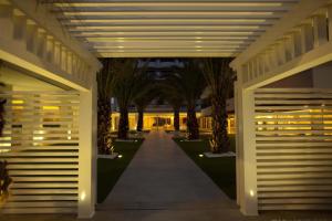 切尔维亚滨海别墅Spa度假酒店的楼内有棕榈树和灯的走廊