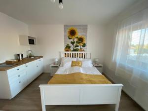 奥巴曹洛克FarmerLand的白色卧室配有一张床和墙上的向日葵