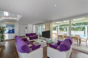 休达德亚Villa Santandria Grupo Seranova Luxury Hotel的客厅配有紫色椅子和电视