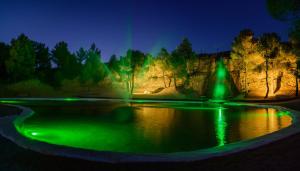 Torre del Compte拉帕拉达德尔孔普特酒店的池塘在晚上点上绿灯