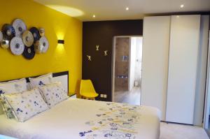 屈克Gîte Autour d'Opale的一间卧室设有一张床和黄色的墙壁
