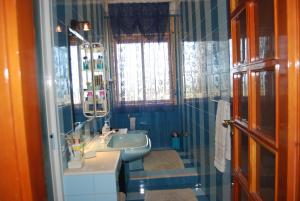 帕洛港2 bedrooms apartement with sea view furnished terrace and wifi at Porto Palo 1 km away from the beach的蓝色的浴室设有水槽和镜子