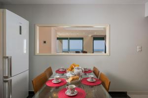 干尼亚Vaggelio House的一间用餐室,配有红色盘子和镜子