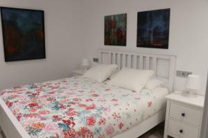 奥维多Boutique & Chic的白色卧室配有带花卉棉被的床