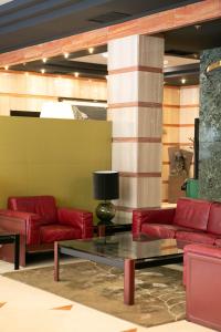 奥维多德城奥维多酒店的大堂设有红色皮沙发和桌子