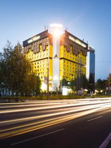 萨拉热窝假日酒店的黄色的建筑,上面有光