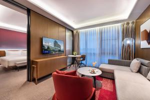 东莞东莞松山湖高新诺富特酒店的酒店客房设有一张沙发和一张床